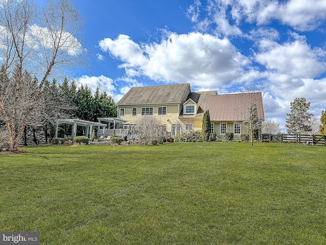 back of property featuring fence, a lawn, and a pergola