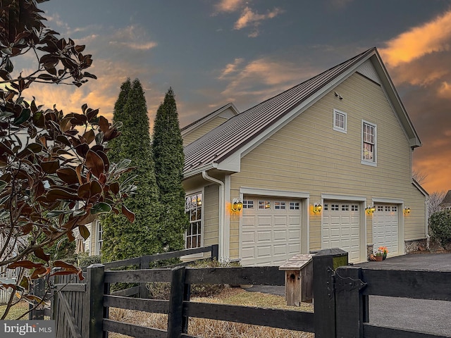 view of front of property featuring a garage, driveway, and fence