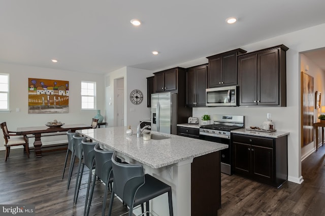 kitchen featuring a sink, an island with sink, dark wood-style flooring, and stainless steel appliances