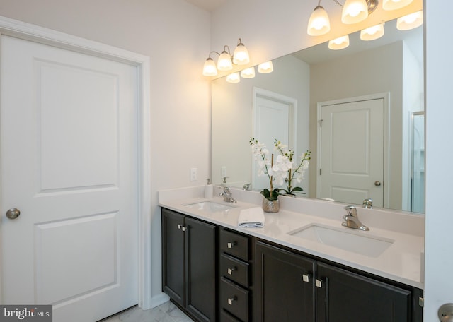 bathroom featuring double vanity, marble finish floor, and a sink