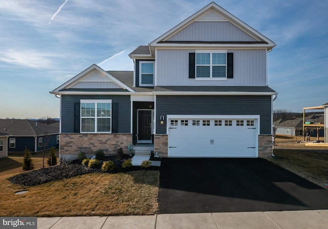 craftsman house featuring aphalt driveway, stone siding, and a garage