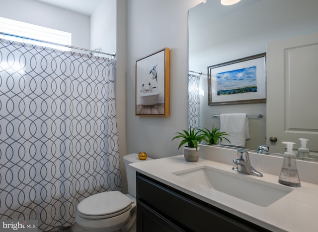 bathroom with curtained shower, toilet, and vanity