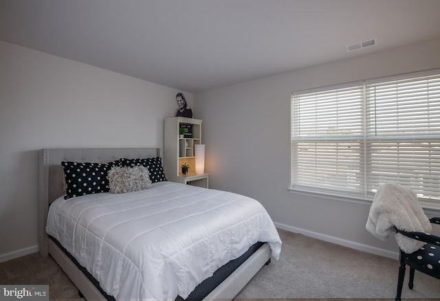 carpeted bedroom featuring visible vents and baseboards