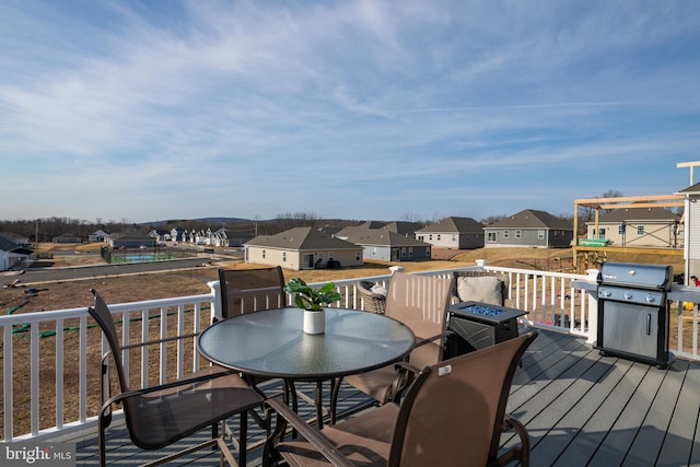 wooden terrace with outdoor dining space, a residential view, and grilling area