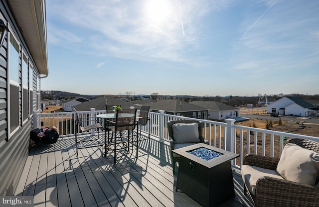 wooden terrace featuring a residential view and a fire pit