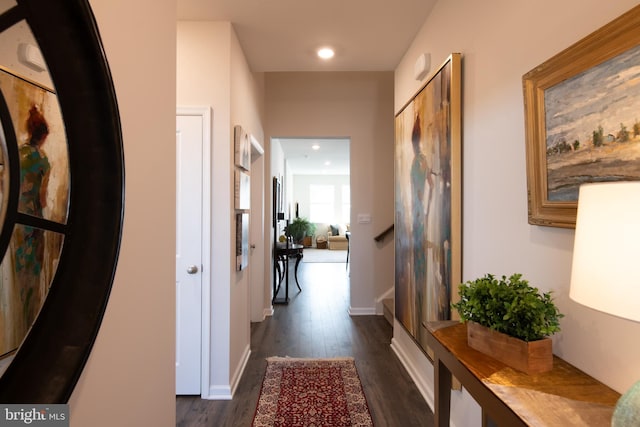 corridor featuring dark wood finished floors, recessed lighting, and baseboards