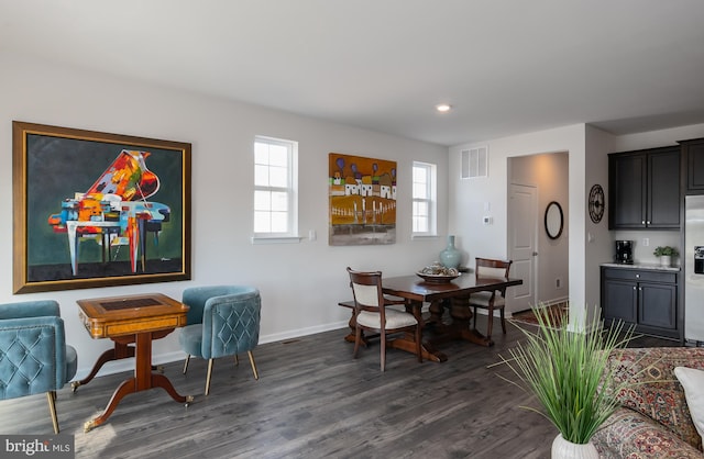 dining room with visible vents, baseboards, and dark wood-style flooring