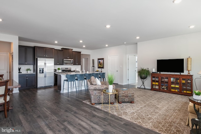 living area with recessed lighting, dark wood-type flooring, and baseboards