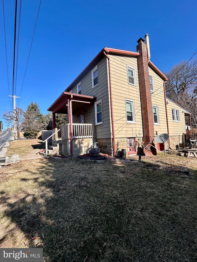 view of side of property with a lawn and a chimney