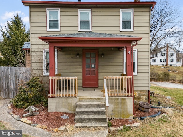 traditional style home with covered porch and fence