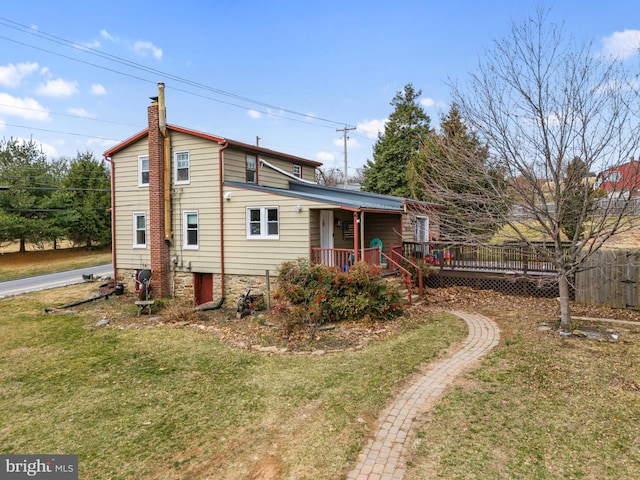 back of property featuring a chimney and a yard