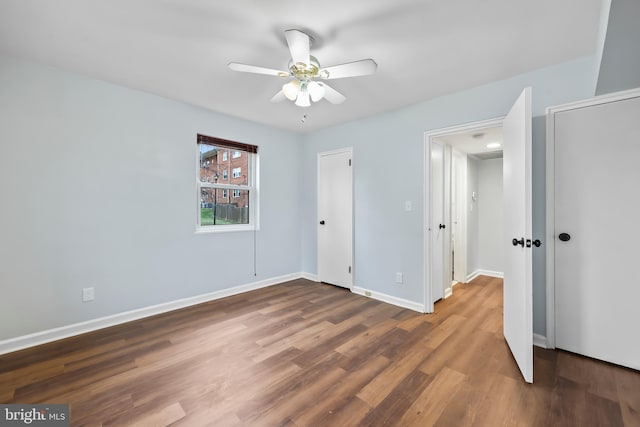 unfurnished bedroom featuring a ceiling fan, wood finished floors, and baseboards