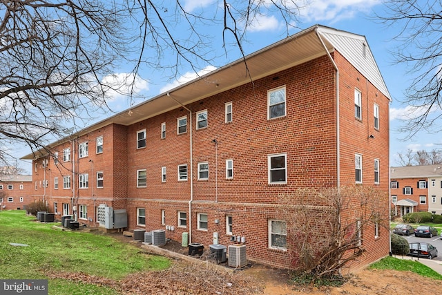 exterior space with brick siding and cooling unit