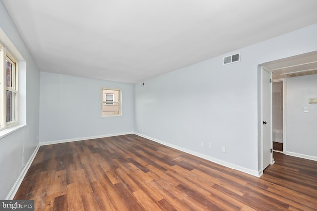 spare room featuring visible vents, baseboards, and wood finished floors