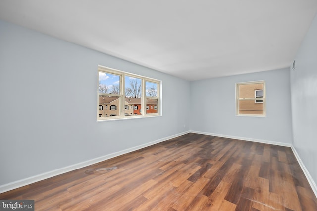 unfurnished room with baseboards and wood finished floors