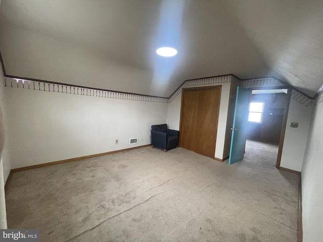 additional living space with lofted ceiling, carpet flooring, visible vents, and baseboards