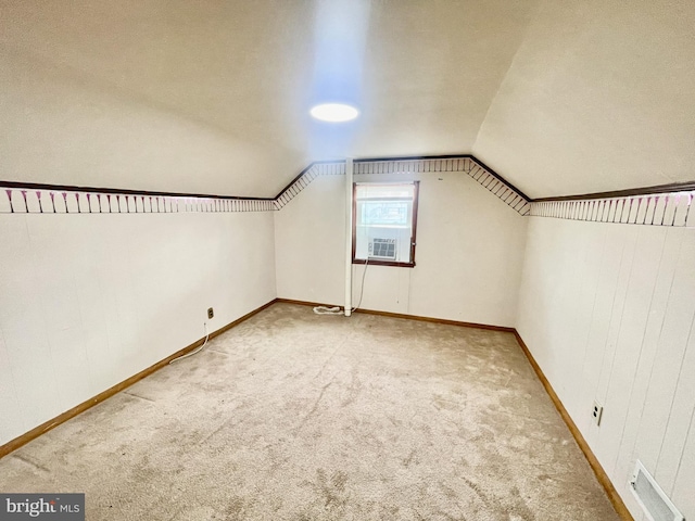 additional living space featuring visible vents, lofted ceiling, baseboards, and carpet flooring