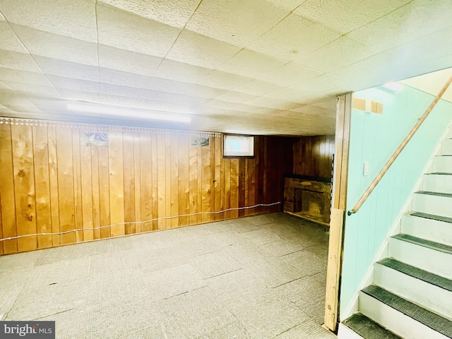 below grade area featuring stairway and wood walls