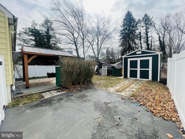 view of yard featuring a storage shed, a patio area, an outbuilding, and a fenced backyard