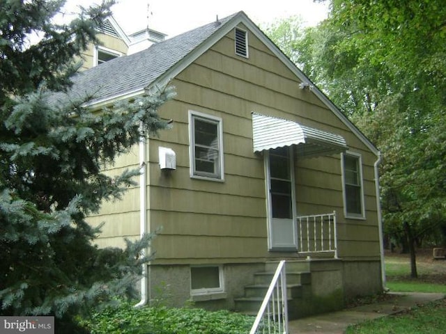 view of property exterior with roof with shingles