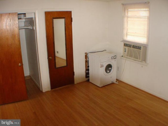 washroom featuring laundry area, light wood-style flooring, cooling unit, and washer / clothes dryer