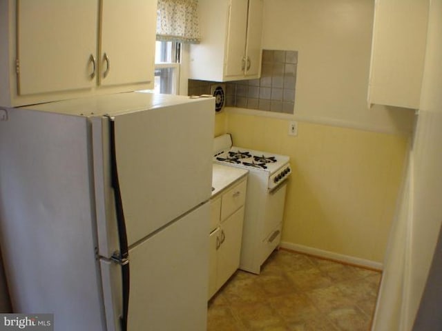 kitchen with backsplash, white appliances, white cabinets, light countertops, and baseboards