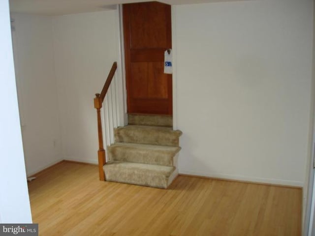 staircase with baseboards and wood finished floors