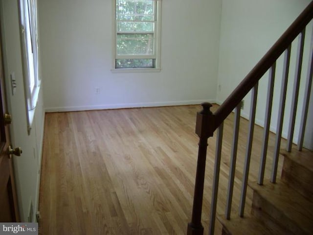 interior space with stairway, baseboards, and wood finished floors