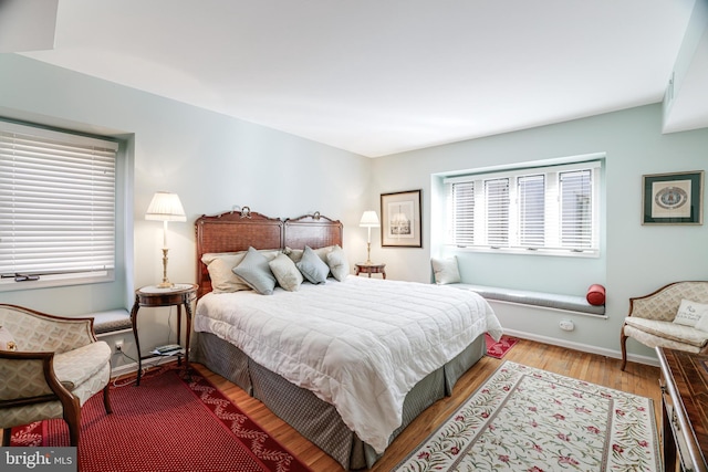 bedroom featuring wood finished floors and baseboards