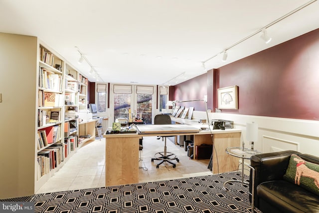 office space with rail lighting, a wainscoted wall, and light tile patterned floors