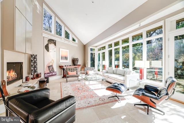 sunroom / solarium featuring lofted ceiling and a high end fireplace