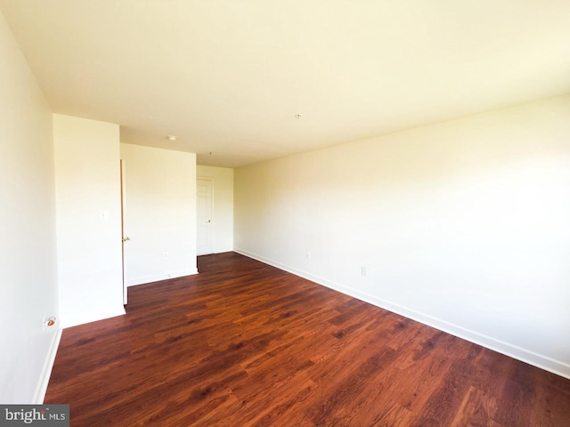 unfurnished room featuring dark wood finished floors and baseboards