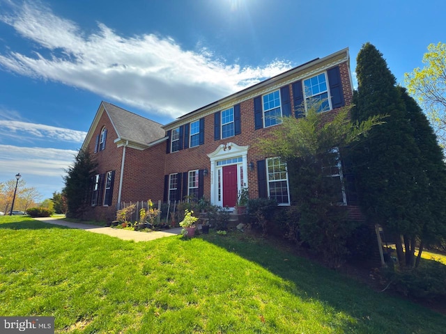 colonial house with brick siding and a front lawn
