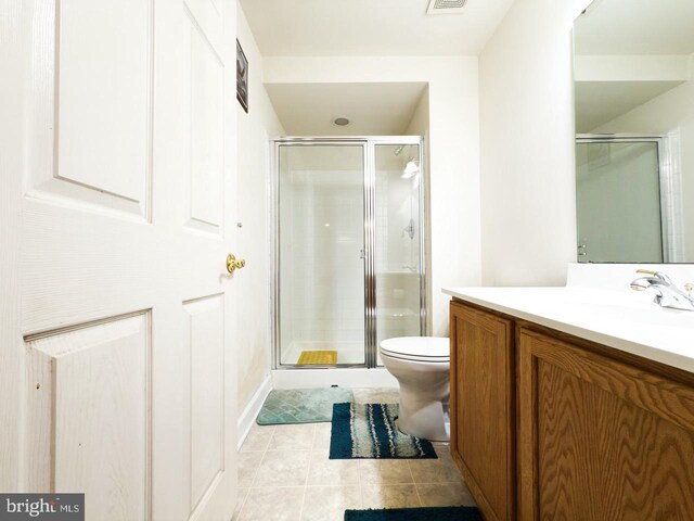 full bathroom with a shower stall, toilet, tile patterned flooring, and vanity
