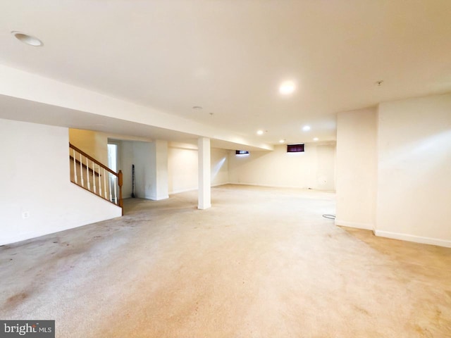 finished below grade area featuring recessed lighting, stairway, baseboards, and light carpet