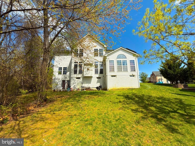 rear view of property featuring a lawn and crawl space