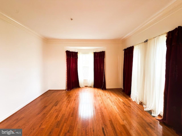 unfurnished room featuring hardwood / wood-style flooring, baseboards, and crown molding