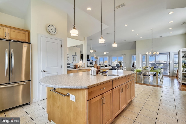 kitchen with visible vents, decorative light fixtures, light tile patterned floors, freestanding refrigerator, and a sink