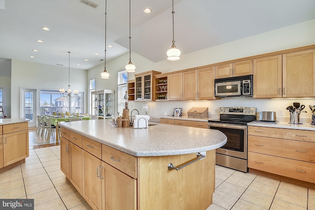 kitchen with light brown cabinetry, stainless steel appliances, and a sink