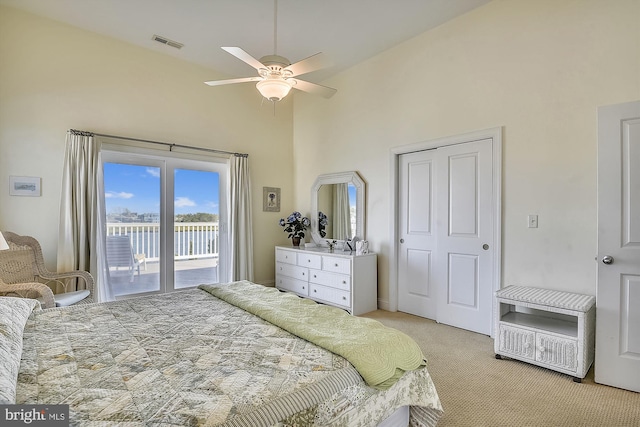 bedroom featuring visible vents, light colored carpet, a towering ceiling, and access to outside