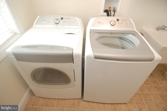 laundry room featuring washer and dryer and light tile patterned floors