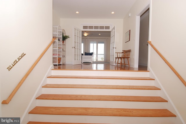 staircase featuring wood finished floors, recessed lighting, french doors, and visible vents