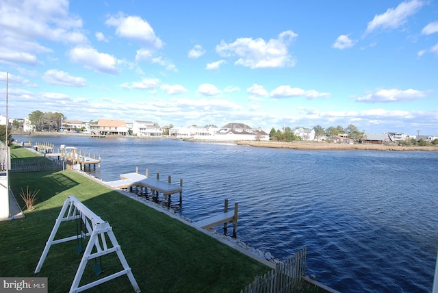 dock area with a yard and a water view