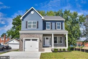 traditional-style house featuring a porch, an attached garage, driveway, and a front yard