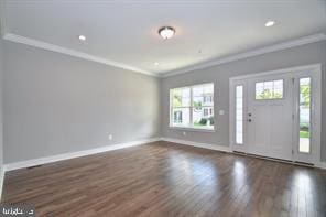 foyer entrance with dark wood finished floors, crown molding, and baseboards