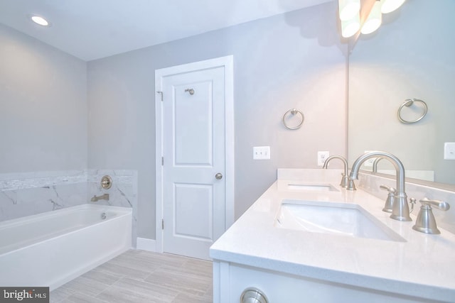 full bath featuring a sink, a garden tub, and double vanity