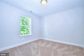 spare room featuring baseboards and carpet floors