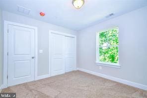 unfurnished bedroom featuring a closet, baseboards, carpet, and visible vents