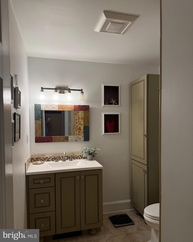 bathroom featuring vanity, visible vents, baseboards, tile patterned flooring, and toilet