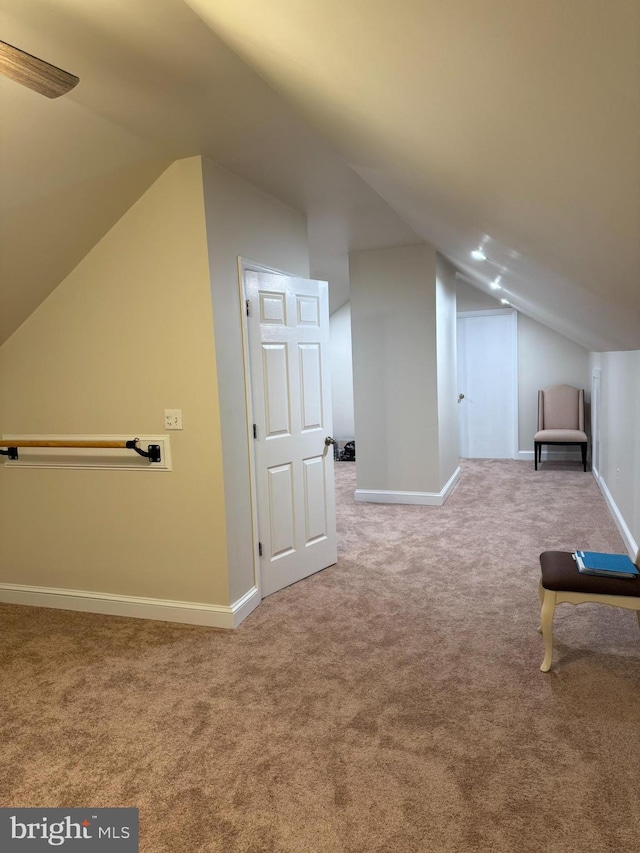 additional living space with baseboards, carpet flooring, and vaulted ceiling